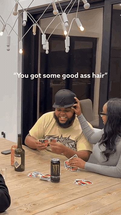 A Man And A Woman Are Playing Cards At A Table With A Can Of Monster Energy Drink In Front Of Them GIF