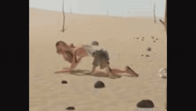 A Man And A Woman Are Playing In The Sand . GIF