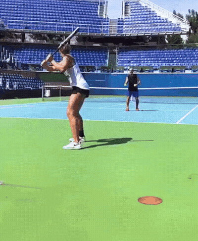 A Man And A Woman Are Playing Tennis On A Tennis Court GIF