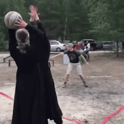 A Man And A Woman Are Playing Volleyball On A Dirt Court GIF
