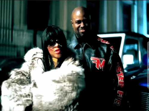 A Man And A Woman Are Posing For A Picture And The Man Is Wearing A Jacket With The Letter M On The Sleeves GIF