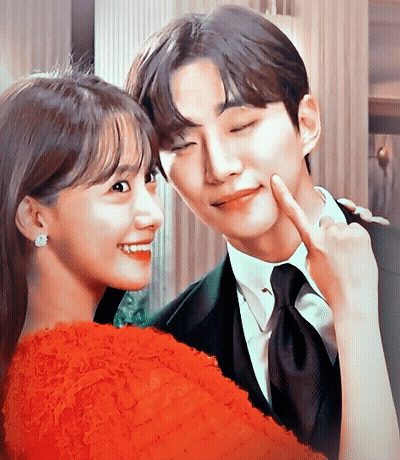 A Man And A Woman Are Posing For A Picture And The Woman Is Wearing A Red Dress GIF