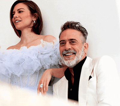 A Man And A Woman Are Posing For A Picture And The Woman Is Wearing A Ring On Her Finger GIF