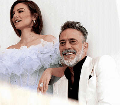 A Man And A Woman Are Posing For A Picture And The Woman Is Wearing A Ring GIF