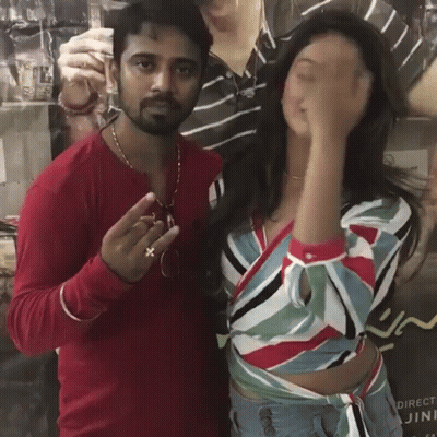 A Man And A Woman Are Posing For A Picture In Front Of A Poster That Says Direct GIF