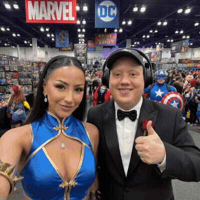 A Man And A Woman Are Posing For A Picture In Front Of A Sign That Says Marvel GIF