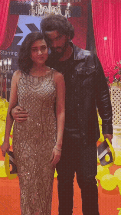 A Man And A Woman Are Posing For A Picture In Front Of A Starring Sign GIF