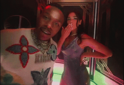 A Man And A Woman Are Posing For A Picture . The Woman Is Wearing A Purple Dress . GIF