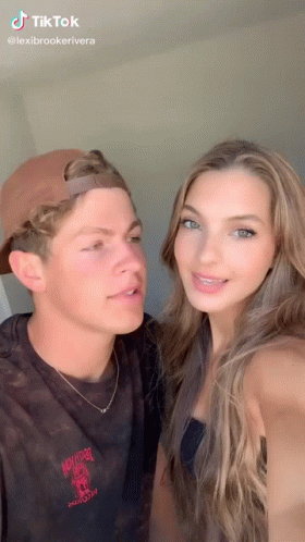 A Man And A Woman Are Posing For A Picture Together . The Woman Is Wearing Braces . GIF