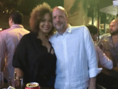 A Man And A Woman Are Posing For A Picture With A Can Of Coca Cola In The Foreground GIF