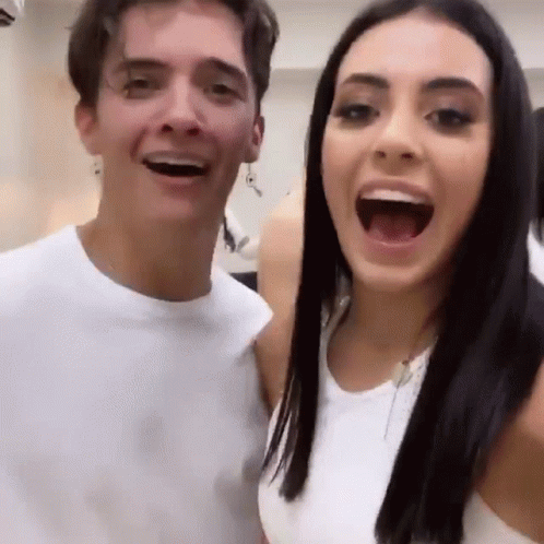 A Man And A Woman Are Posing For A Picture With Their Mouths Open And Smiling . GIF