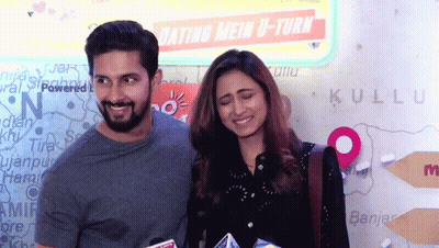 A Man And A Woman Are Posing In Front Of A Sign That Says Dating Mein U-Turn GIF
