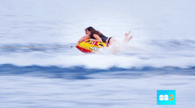 A Man And A Woman Are Riding A Raft In The Ocean With The Letters Sbs On The Bottom GIF