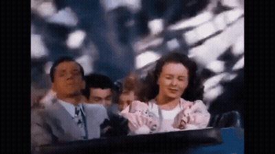 A Man And A Woman Are Riding A Roller Coaster Together . GIF
