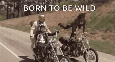 A Man And A Woman Are Riding Motorcycles Down A Road With The Words `` Born To Be Wild '' . GIF