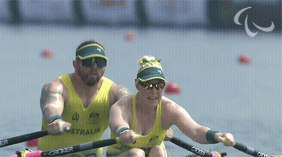 A Man And A Woman Are Rowing In A Boat That Says Australia On The Front GIF
