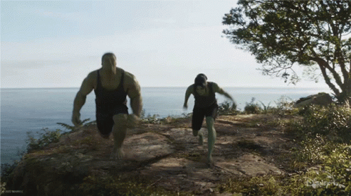A Man And A Woman Are Running On A Trail With A Disney Logo In The Corner GIF