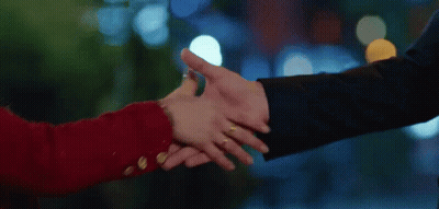 A Man And A Woman Are Shaking Hands And The Woman Has A Ring On Her Finger GIF