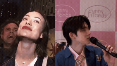 A Man And A Woman Are Singing Into Microphones In Front Of A Funny Friends Sign GIF