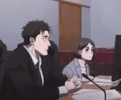 A Man And A Woman Are Sitting At A Desk In Front Of A Microphone . GIF