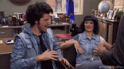 A Man And A Woman Are Sitting At A Desk With The Hashtag #Parksandrec On The Bottom Right GIF