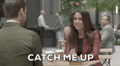 A Man And A Woman Are Sitting At A Table And The Woman Is Saying Catch Me Up GIF