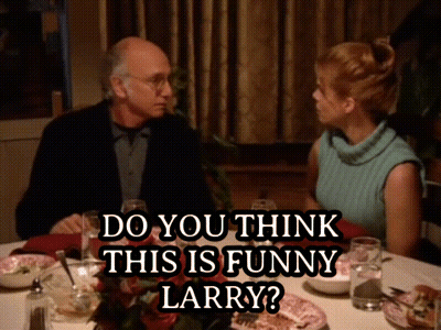 A Man And A Woman Are Sitting At A Table With A Caption That Says " Do You Think This Is Funny Larry " GIF