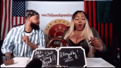 A Man And A Woman Are Sitting At A Table With A Sign That Says " All This Shit Said Is Alleged By " GIF