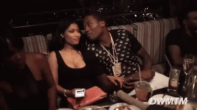 A Man And A Woman Are Sitting At A Table With Dwmtm Written In The Corner GIF