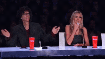 A Man And A Woman Are Sitting At A Table With Red Cups That Say Coca Cola On Them . GIF