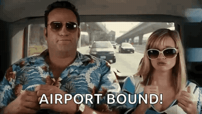 A Man And A Woman Are Sitting In A Car And The Woman Is Giving A Thumbs Up . GIF