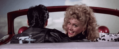 A Man And A Woman Are Sitting In A Car . GIF