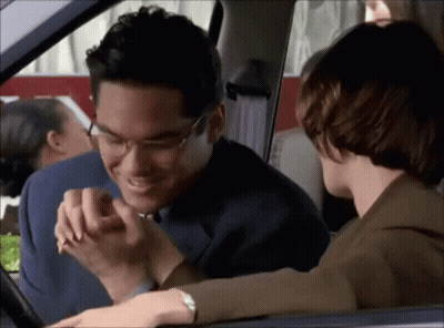 A Man And A Woman Are Sitting In A Car Holding Hands GIF