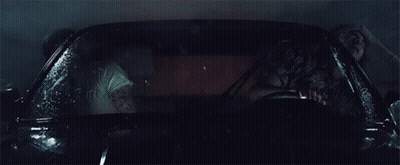 A Man And A Woman Are Sitting In A Car That Is Covered In Water GIF