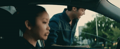 A Man And A Woman Are Sitting In A Car . The Woman Is Looking Out The Window . GIF