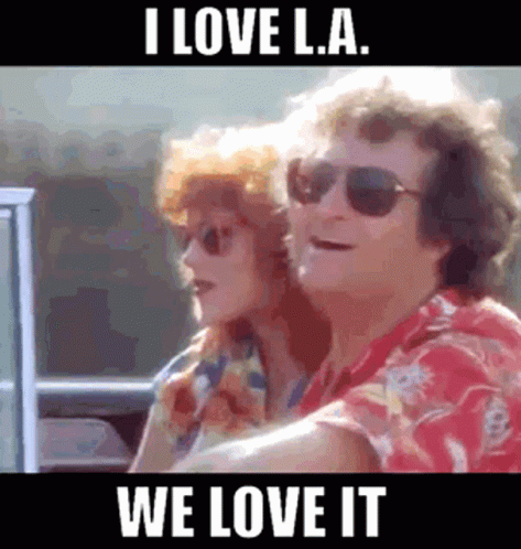 A Man And A Woman Are Sitting In A Car With The Caption I Love La We Love It GIF