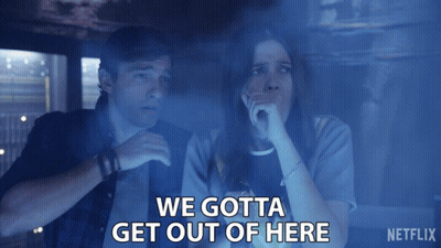 A Man And A Woman Are Sitting In A Dark Room With The Words " We Gotta Get Out Of Here " Above Them GIF