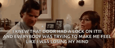 A Man And A Woman Are Sitting In A Living Room Talking To Each Other . The Woman Is Wearing Glasses . GIF