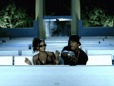 A Man And A Woman Are Sitting In A Row Of Seats GIF