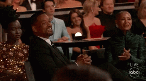 A Man And A Woman Are Sitting In A Theatre Watching A Live Abc Broadcast GIF