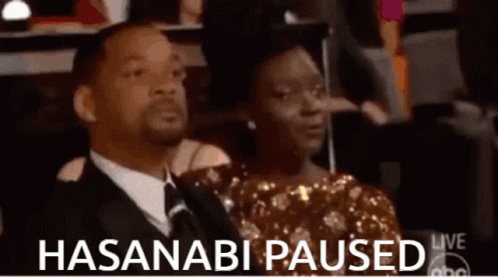 A Man And A Woman Are Sitting In A Theatre With The Words " Hasanabi Paused " On The Bottom GIF