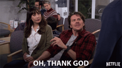 A Man And A Woman Are Sitting In A Waiting Room With The Words Oh Thank God Above Them GIF