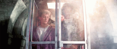 A Man And A Woman Are Sitting In An Elevator . GIF