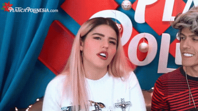 A Man And A Woman Are Sitting In Front Of A Sign That Says " Poli " GIF