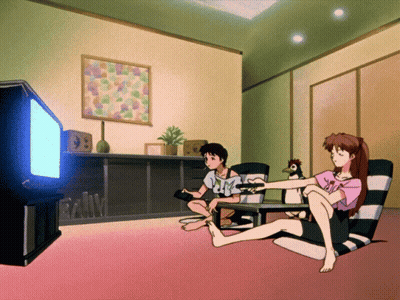 A Man And A Woman Are Sitting In Front Of A Tv GIF