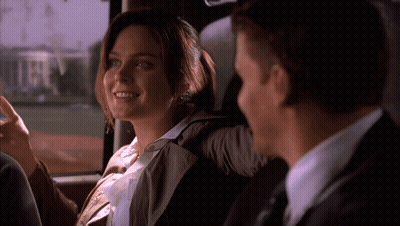 A Man And A Woman Are Sitting In The Back Seat Of A Car And The Woman Is Smiling GIF