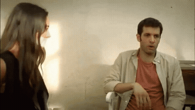 A Man And A Woman Are Sitting Next To Each Other And Talking To Each Other . GIF