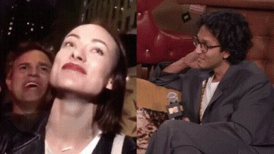 A Man And A Woman Are Sitting Next To Each Other And The Man Is Wearing Glasses GIF
