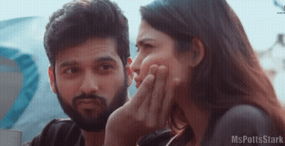 A Man And A Woman Are Sitting Next To Each Other And The Woman Is Covering Her Face With Her Hand . GIF