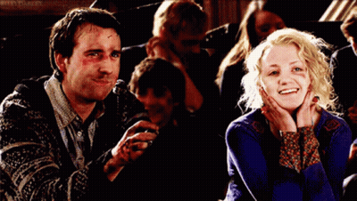 A Man And A Woman Are Sitting Next To Each Other And The Woman Is Smiling GIF
